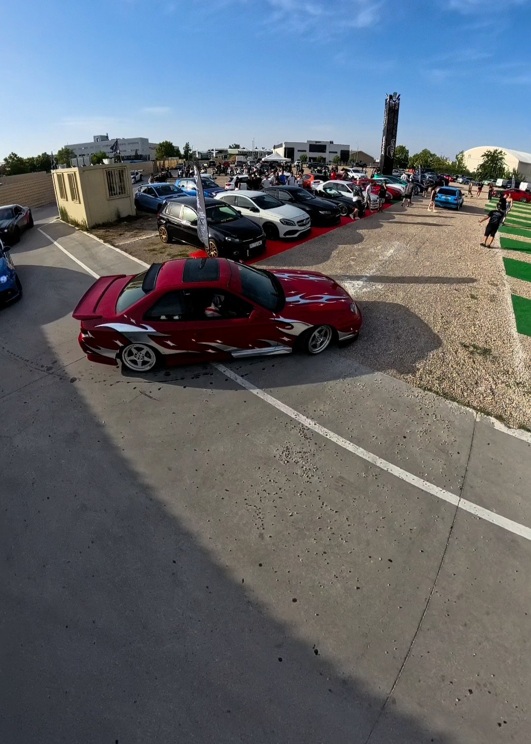 Coupé japonés rojo con kit ancho en una quedada